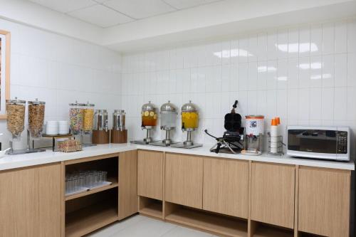 a kitchen with wooden cabinets and a microwave at Hampton by Hilton Saltillo Zona Aeropuerto in Saltillo