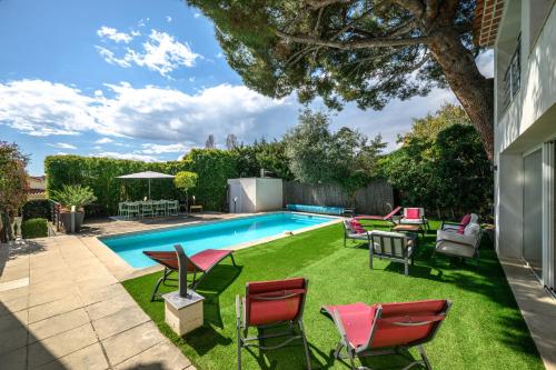 une cour arrière avec une piscine avec des chaises et une table dans l'établissement Splendide villa/piscine vue mer, à Nice