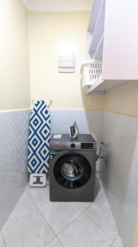 a bathroom with a washing machine in a room at Oreville Apartments in Goma