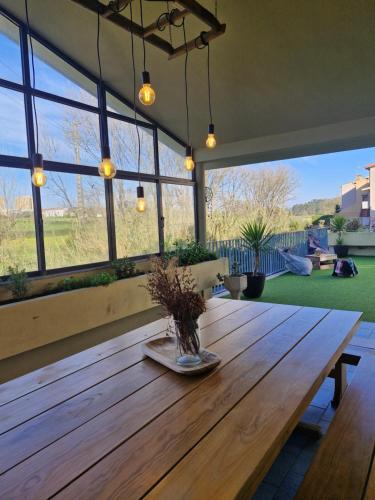 a large wooden table in a room with windows at Azurara Guesthouse in Azurara
