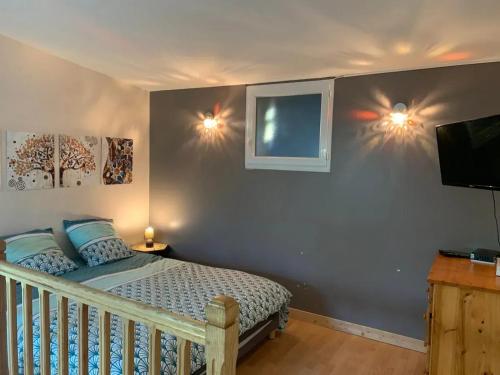 ein Schlafzimmer mit einem Bett mit zwei Lichtern an der Wand in der Unterkunft Charmante maison avec piscine à Chalandray, 25 m² in Chalandray