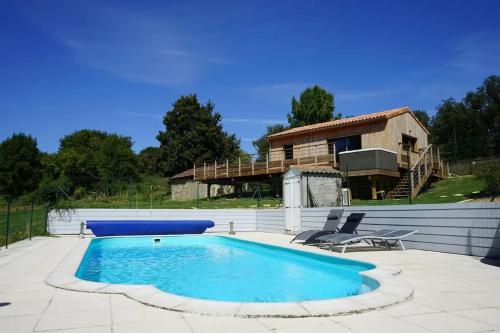 une piscine avec une maison en arrière-plan dans l'établissement Charmante maison avec piscine à Chalandray, 25 m², à Chalandray