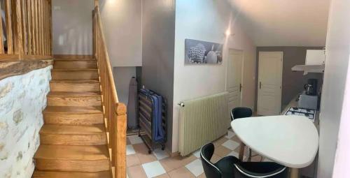Zimmer mit einer Treppe mit einem weißen Tisch und Stühlen in der Unterkunft Charmante maison avec piscine à Chalandray, 25 m² in Chalandray