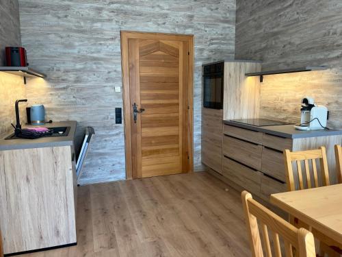 a kitchen with a wooden door and a table at Sun Apartments - with Dolomiten Panorama in Lienz