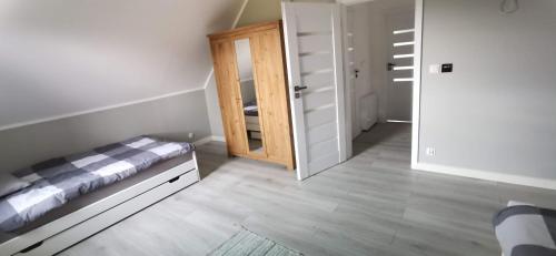 a bedroom with a bed and a closet and a mirror at Willa Prądocin nad Jeziorem Jezuickim in Prądocin
