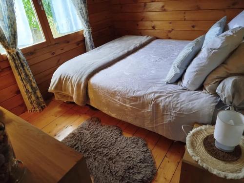 una camera con un letto in una baita di tronchi di Chalet confortable à Attin - 36 m² avec jardin a Attin