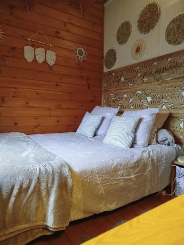 - une chambre avec un lit et un mur en bois dans l'établissement Chalet confortable à Attin - 36 m² avec jardin, à Attin