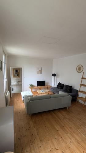 un salon avec un canapé et une table dans l'établissement Maison calme avec terasse proche centre ville, à La Rochelle