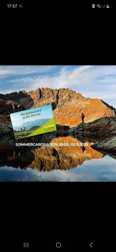 a poster of a mountain with a person standing on a hill at Aloha Suite - Schladming Dachstein in Haus im Ennstal