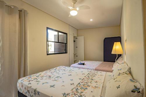 una piccola camera da letto con due letti e una finestra di Casa no Perequê Guarujá c/ Wi-Fi e Churrasqueira a Bertioga