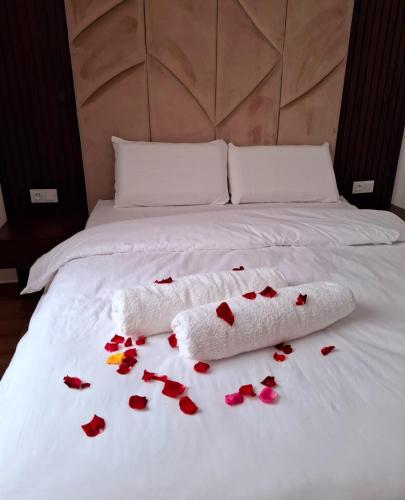 a white bed with red roses on it at Appartement Ghita Essaouira in Essaouira