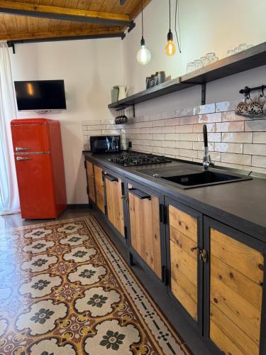 a kitchen with a sink and a red refrigerator at Appartamento Porto Marina S G 2 in Licata