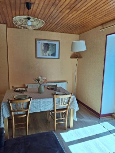 une salle à manger avec une table et des chaises et un plafond dans l'établissement Maison de Bourg, à Rochefort-Montagne