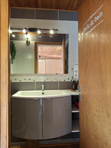 une salle de bain avec un lavabo et un miroir dans l'établissement Maison de Bourg, à Rochefort-Montagne