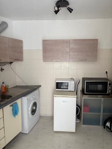 une cuisine avec un lave-linge et un micro-ondes dans l'établissement Appartement bord de mer, à Nice