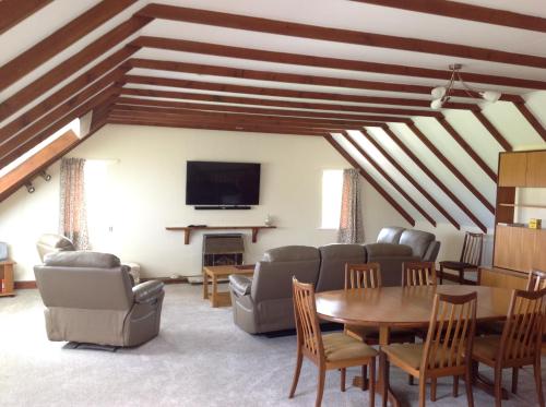 a living room with a table and a tv at Stow House in Berwick-Upon-Tweed