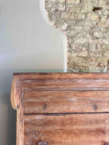 a wooden dresser in front of a stone wall at Highend Cotswold Barn near Soho Farmhouse & Daylesford in Duns Tew
