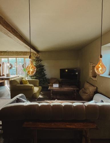 a living room with a couch and a table at Highend Cotswold Barn near Soho Farmhouse & Daylesford in Duns Tew