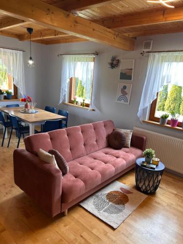 a living room with a pink couch and a table at Sielanka Chwaliszów dom całoroczny in Chwaliszow