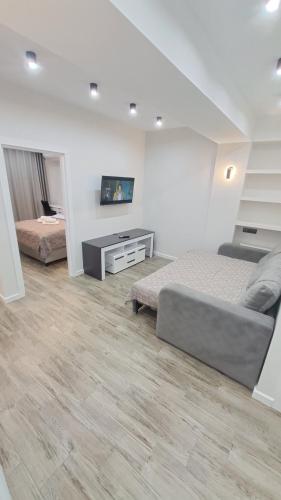 a bedroom with two beds and a tv on the wall at Жуляны in Chişinău