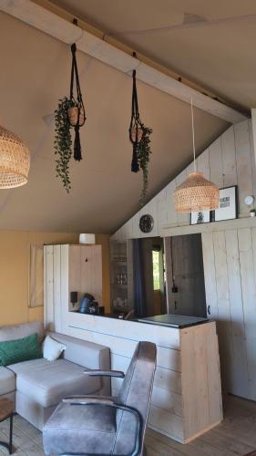 a living room with a couch and a table at Luxe Safaritent in Grou in Grou