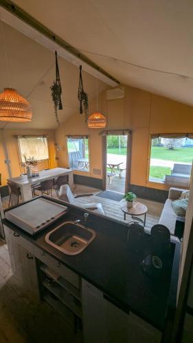 a kitchen and living room with a table and a couch at Luxe Safaritent in Grou in Grou