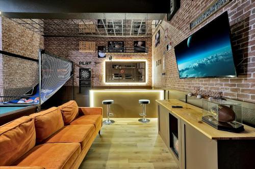 a living room with a couch and a flat screen tv at Epic Orlando Mansion-Pool-Game Room-Theater-2 in Orlando