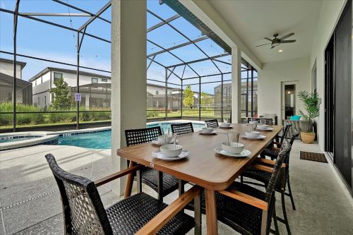 a dining room with a table and chairs and a pool at Epic Orlando Mansion-Pool-Game Room-Theater-2 in Orlando