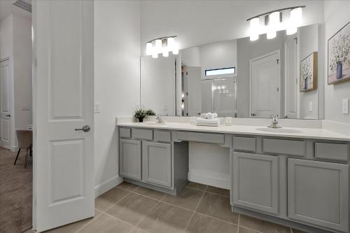 a bathroom with two sinks and a large mirror at Epic Orlando Mansion-Pool-Game Room-Theater-2 in Orlando