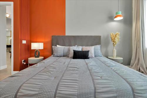 a large bed in a bedroom with an orange wall at Epic Orlando Mansion-Pool-Game Room-Theater-2 in Orlando