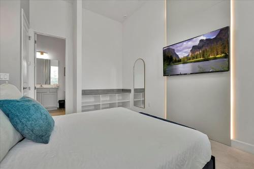 a bedroom with a white bed and a tv on the wall at Epic Orlando Mansion-Pool-Game Room-Theater-2 in Orlando