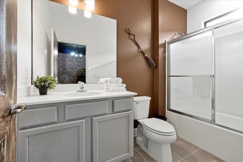 a bathroom with a toilet and a sink and a shower at Epic Orlando Mansion-Pool-Game Room-Theater-2 in Orlando