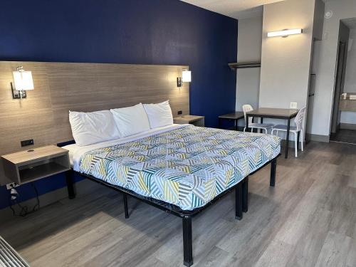 a bedroom with a bed with a blue wall at Studio Suites Extended Stay Chattanooga in Silverdale