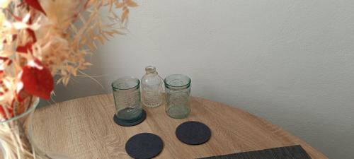 two glass bottles sitting on top of a wooden table at Einzimmerwohnung mit Doppelbett in Nagold