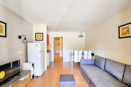 un salon avec un canapé et une cuisine dans l'établissement La résidence du Lac - maeva Home - Appartement 2 pièces 4 personnes - Sélection MAE-5611, à Monflanquin