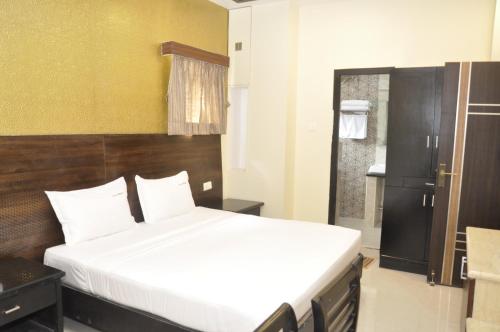 a bedroom with a large bed and a bathroom at Hotel Grand Parkway in Tambaram