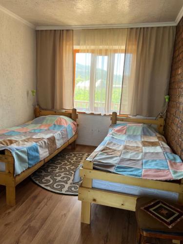 a bedroom with two beds and a window at Eco Village Lodge in Dzhetyoguz