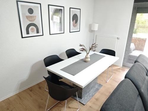 a white dining room with a white table and chairs at FH-Nähe: Modernes Apt mit Balkon in Hof