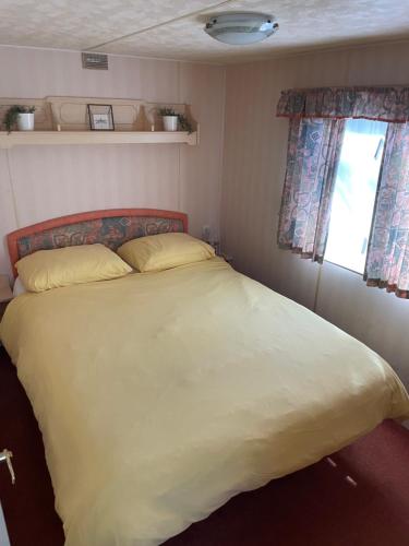 a bedroom with a large bed with two pillows and a window at Vintage Forest Chalet in IJhorst