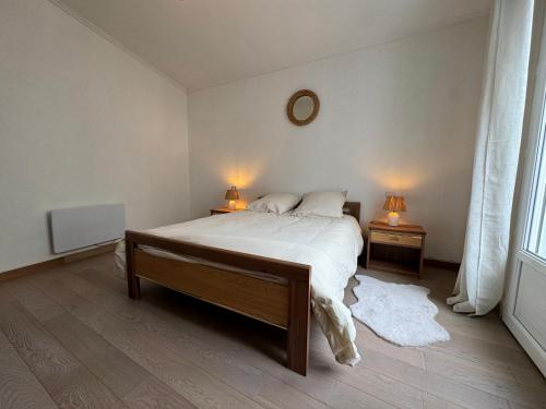 - une chambre avec un lit et deux lampes sur deux tables dans l'établissement T2 à 100M de Plage et Terrasse, à Les Sables-dʼOlonne