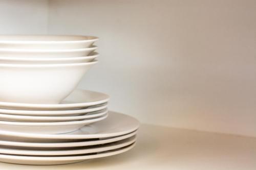 a stack of white plates sitting on a table at Long Beach Selfcatering Namibia in Langstrand