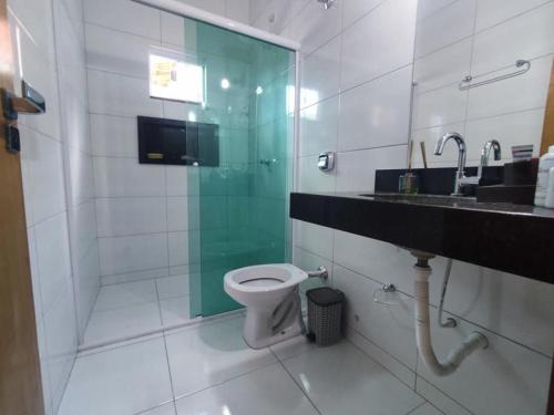 a bathroom with a shower and a toilet and a sink at Casa Com Piscina Aquecida in Caldas Novas