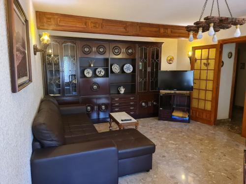 a living room with a couch and a tv at La casa del Alamo in Vinuesa