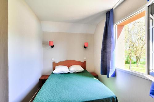 une petite chambre avec un lit et une fenêtre dans l'établissement La résidence du Lac - maeva Home - Appartement 3 pièces 6 personnes - Sélection MAE-0401, à Monflanquin