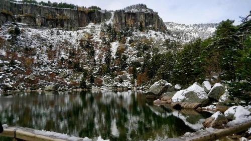 a lake in the mountains with snow on the rocks at La casa del Alamo in Vinuesa