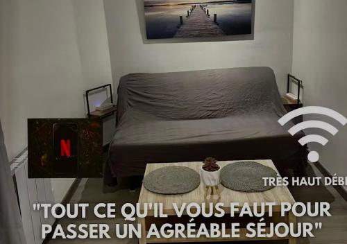 une petite chambre avec un lit et une table dans l'établissement Dépendance cosy près de Paris, à Vernouillet