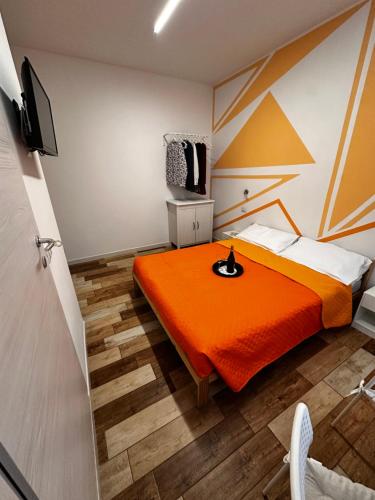 a hotel room with a bed with an orange blanket at Coro & Bentu in Alghero