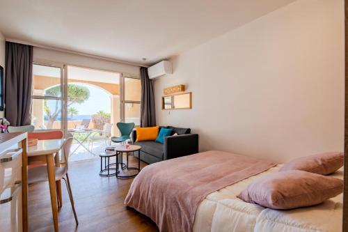 une chambre avec un lit et un salon dans l'établissement Résidence le Village de Cap Esterel - maeva Home - Appartement vue mer 2 pièces 4 personnes - Prestige - super Home MAE-2171, à Saint-Raphaël