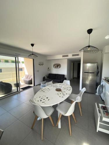 une table blanche et des chaises dans un salon dans l'établissement Allée des Oliviers - maeva Home - Appartement 3 pièces 6 personnes - Prestige MAE-5001, à Saint-Elme