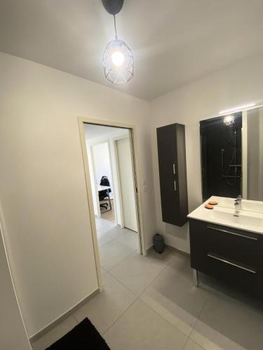 une salle de bain avec un lavabo et un miroir dans l'établissement Allée des Oliviers - maeva Home - Appartement 3 pièces 6 personnes - Prestige MAE-5001, à Saint-Elme